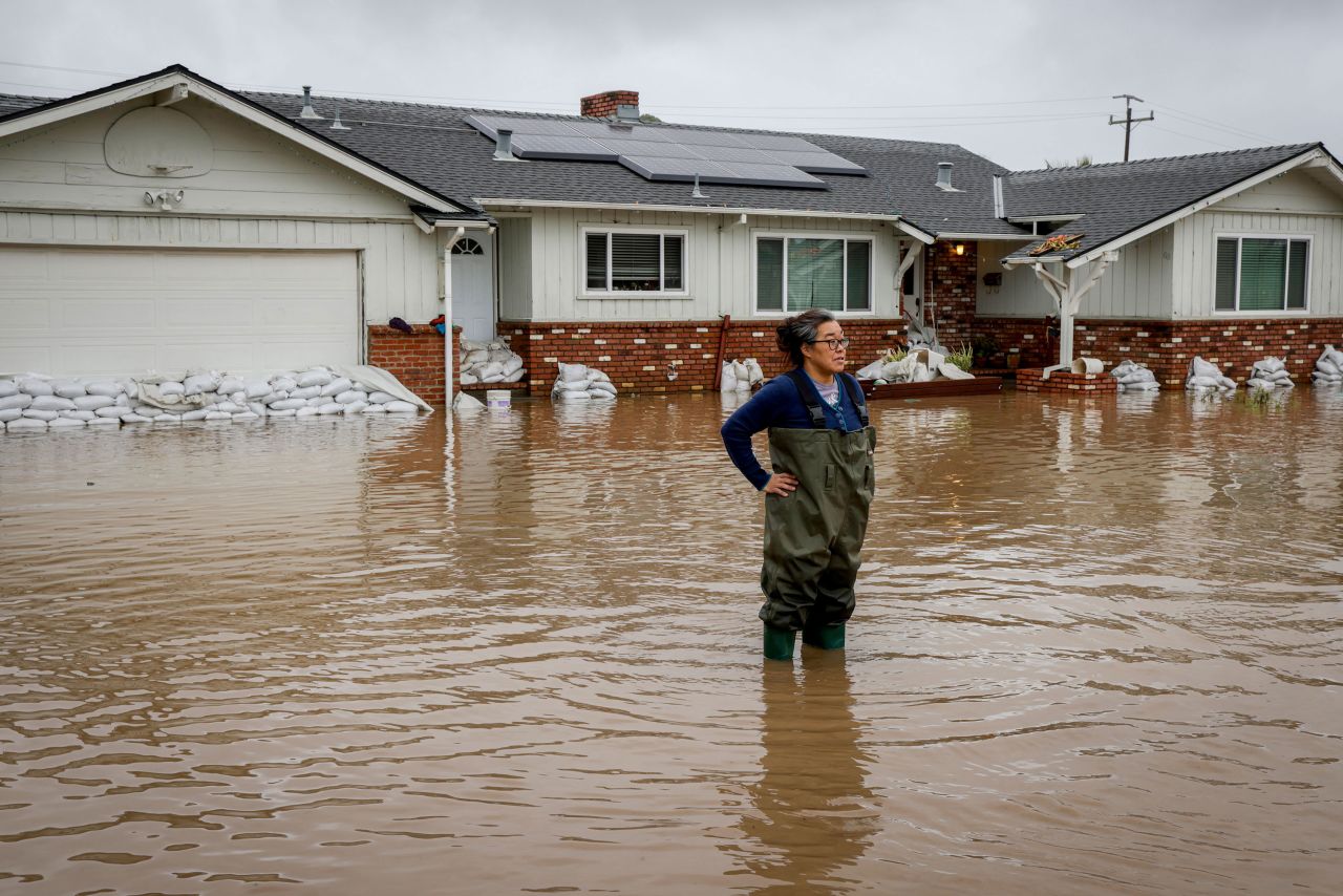 Colleen Kumada-McGowan stands in floodwaters in front of her home in Watsonville on January 9.
