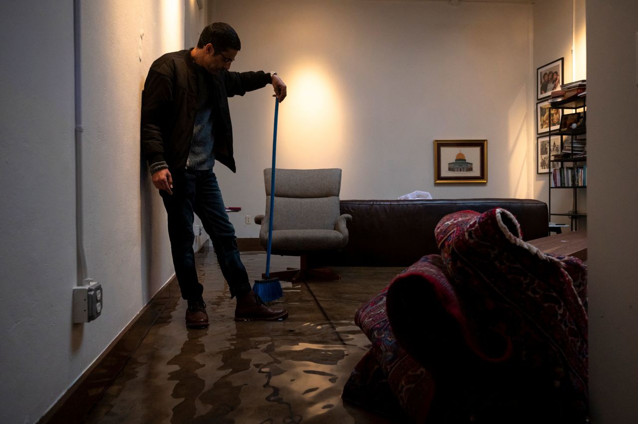 Khaled Dajani clears water from his flooded living room in San Francisco on December 31.