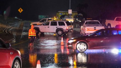 A Caltrans worker directs traffic at a freeway entrance as U.S. Highway 101 is closed near Montecito, California on Monday.