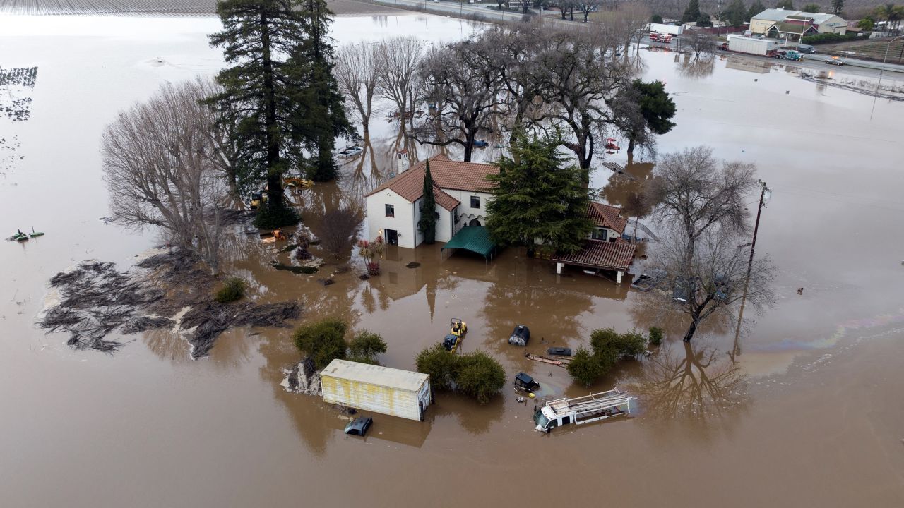 TOPSHOT - This aerial view shows a flooded home partially underwater in Gilroy, California, on January 9, 2023. - A massive storm called a bomb cyclone" by meteorologists has arrived and is expected to cause widespread flooding throughout the state. (Photo by JOSH EDELSON / AFP) (Photo by JOSH EDELSON/AFP via Getty Images)