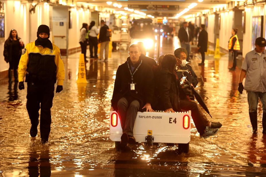 Commuters in downtown Los Angeles are shuttled over a flooded section of a pedestrian walkway leading to train platforms on the main level of Union Station.