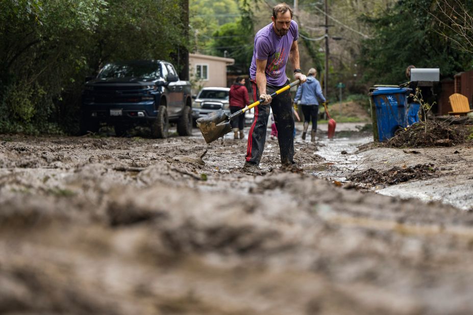 Matt O'Brien shovels mud from a driveway on Tuesday after the San Lorenzo River overflowed in Felton.