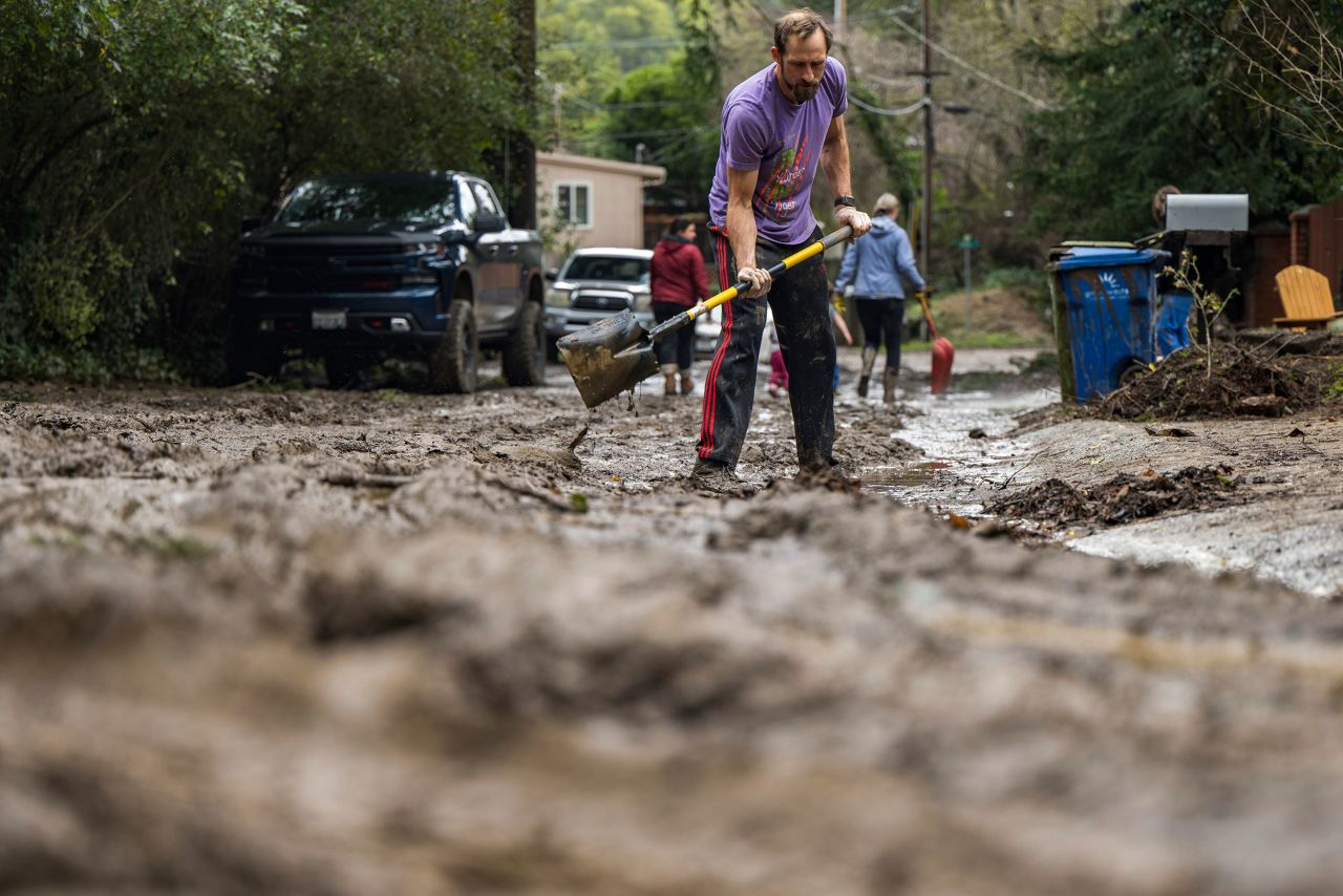 Matt O'Brien shovels mud from a driveway on January 10 after the San Lorenzo River overflowed in Felton.