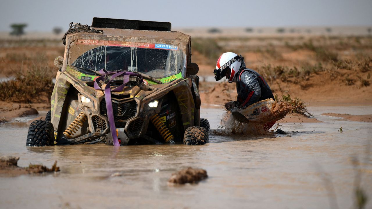Spanish co-driver Lopez Themis tries to get his car out of the mud during Stage 9 of the Dakar 2023 rally in Saudi Arabia on January 10.