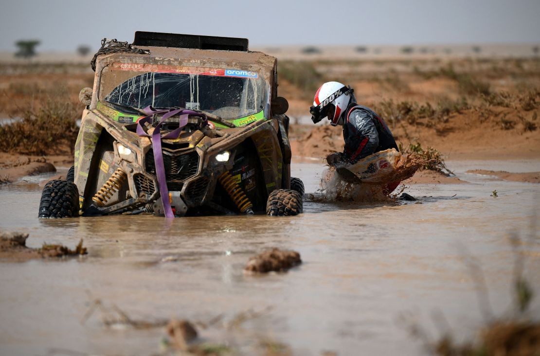 Spanish co-driver Lopez Themis tries to get his car out of the mud during Stage 9 of the Dakar 2023 rally in Saudi Arabia on January 10.