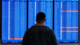 A traveler looks at a flight board with delays and cancellations at Ronald Reagan Washington National Airport in Arlington, Va., Wednesday, Jan. 11, 2023. Flights are being delayed at multiple locations across the United States after a computer outage at the Federal Aviation Administration. (AP Photo/Patrick Semansky)