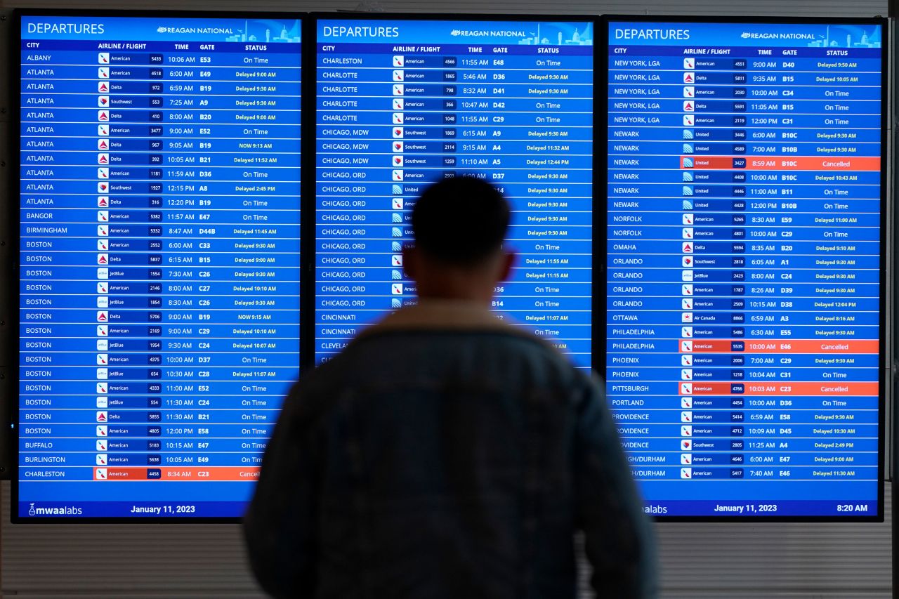 A traveler looks at a flight board with delays and cancellations at Ronald Reagan Washington National Airport on January 11. 