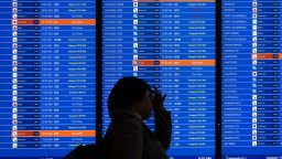 Travelers looks at a flight information display listing cancelled and delayed flights due to an FAA outage that grounded flights across the US at Ronald Reagan Washington National Airport in Arlington, Virginia, January 11, 2023. - The US Federal Aviation Authority  said Wednesday that normal flight operations "are resuming gradually" across the country following an overnight systems outage that grounded departures. (Photo by SAUL LOEB / AFP) (Photo by SAUL LOEB/AFP via Getty Images)