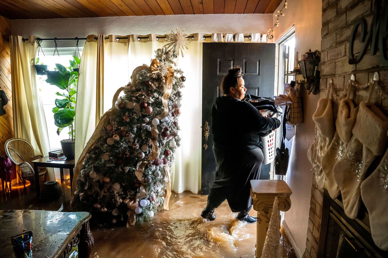 Pauline Torres carries belongings from her flooded home in Merced on January 10.