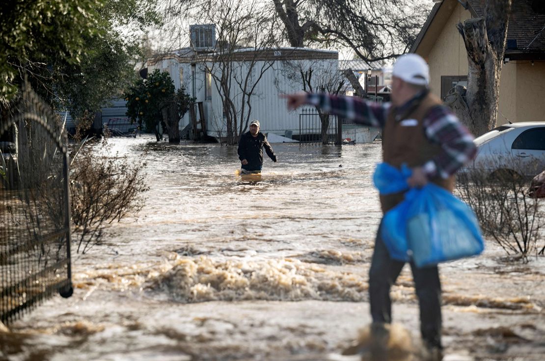 Residents scramble to collect belongings Wednesday before floodwater rises in Merced, California.