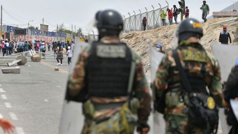 Security forces pictured on January 4, 2023 stand next to debris left by protesters attempting to take control of the Peruvian Andean city of Arequipa. 