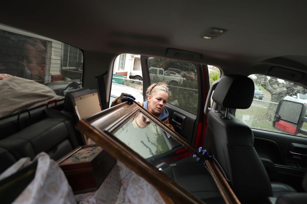 Kelly Slate packs a mirror in the back of a truck after her home was flooded in Planada on Wednesday, January 11.