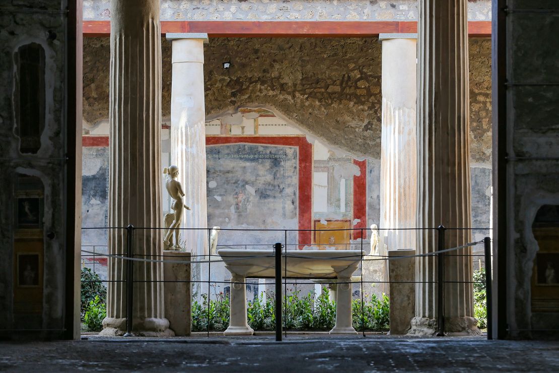 The courtyard of the House of the Vettii with a statue of Priapus, in the archaeological excavations of Pompeii.
