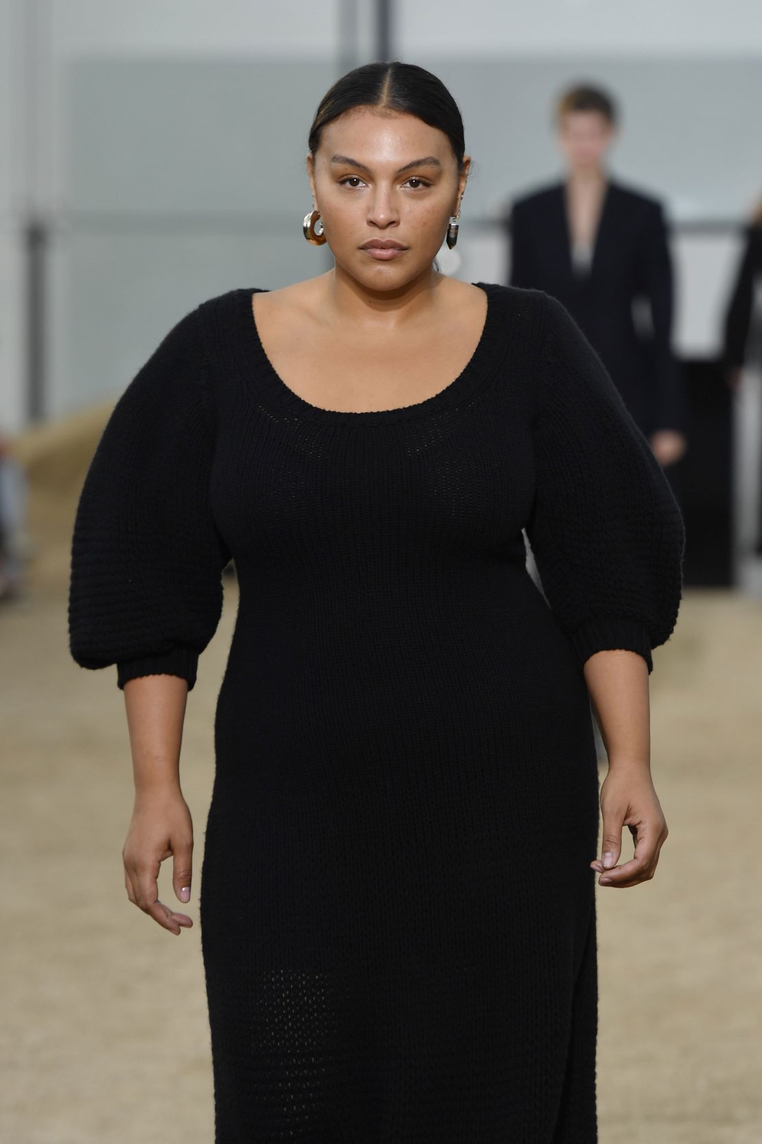 Model Paloma Elsesser walks the runway during the Chloe 2022 show in a black dress for every day. 