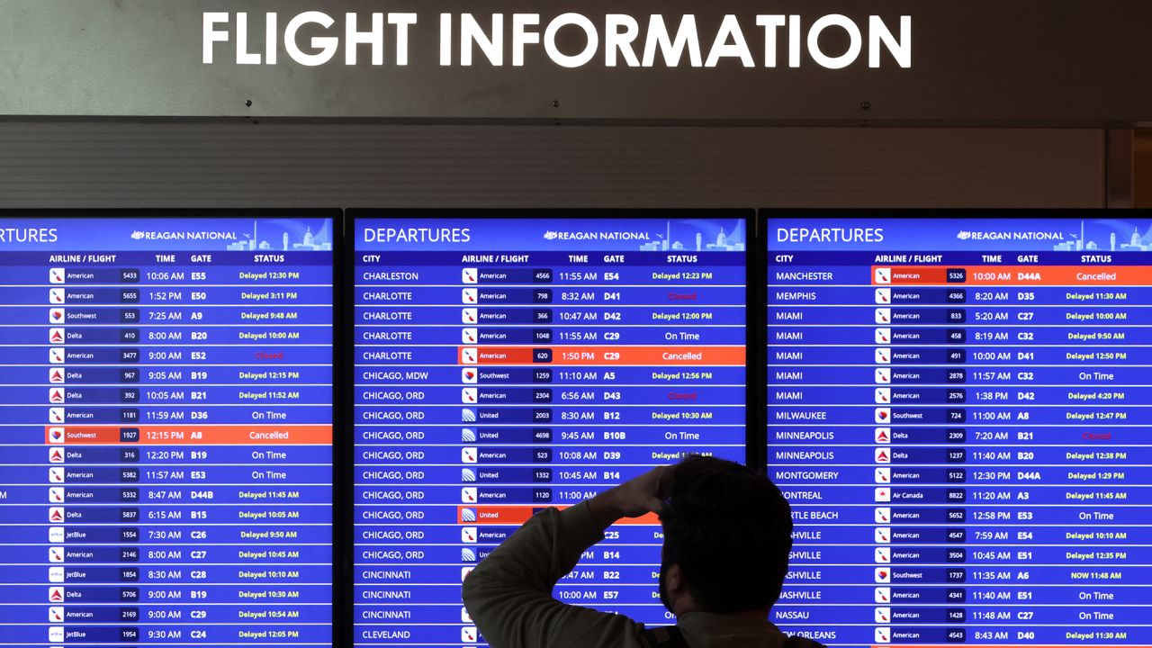 A traveler looks at a flight information board at Ronald Reagan Washington National Airport on January 11, 2023 in Arlington, Virginia. The FAA said it is gradually resuming flights around the country after an outage to the Notice to Air Mission System, a computer system that helps guide air traffic. 