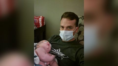 Jason Hecht holds baby Leon in the hospital just hours before being intubated.