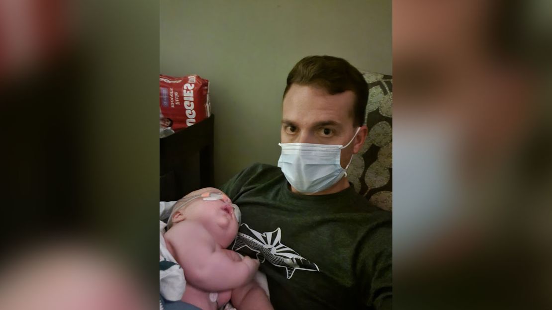 Jason Hecht holds his baby, Leon, at a hospital just hours before he was intubated.