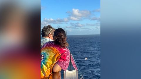 A boat of migrants is seen from an upper deck of the Celebrity Beyond cruise ship.