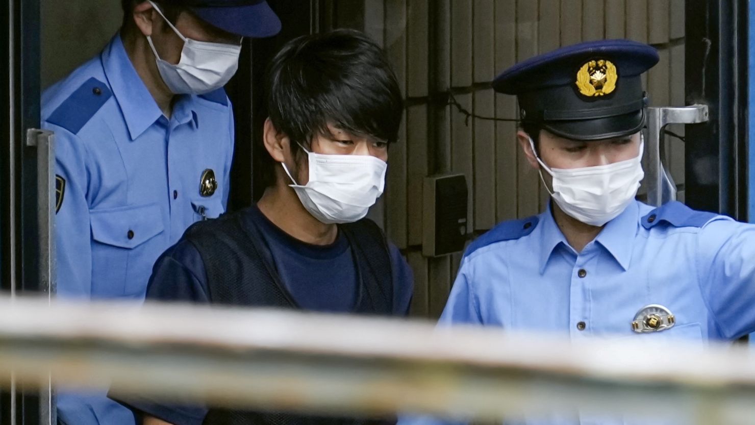 Tetsuya Yamagami is escorted by police officers at a police station in Nara, western Japan on July 10, 2022. 