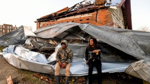 Cartel Deuce e Devo McGraw siedono sul tetto di un edificio industriale e circondano la loro casa dopo che un tornado si è abbattuto giovedì su Selma, in Alabama.