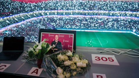 Flowers and a picture of Wahl are seen in the media area during the World Cup 2022 quarterfinal between England and France at the Al Bayt Stadium.