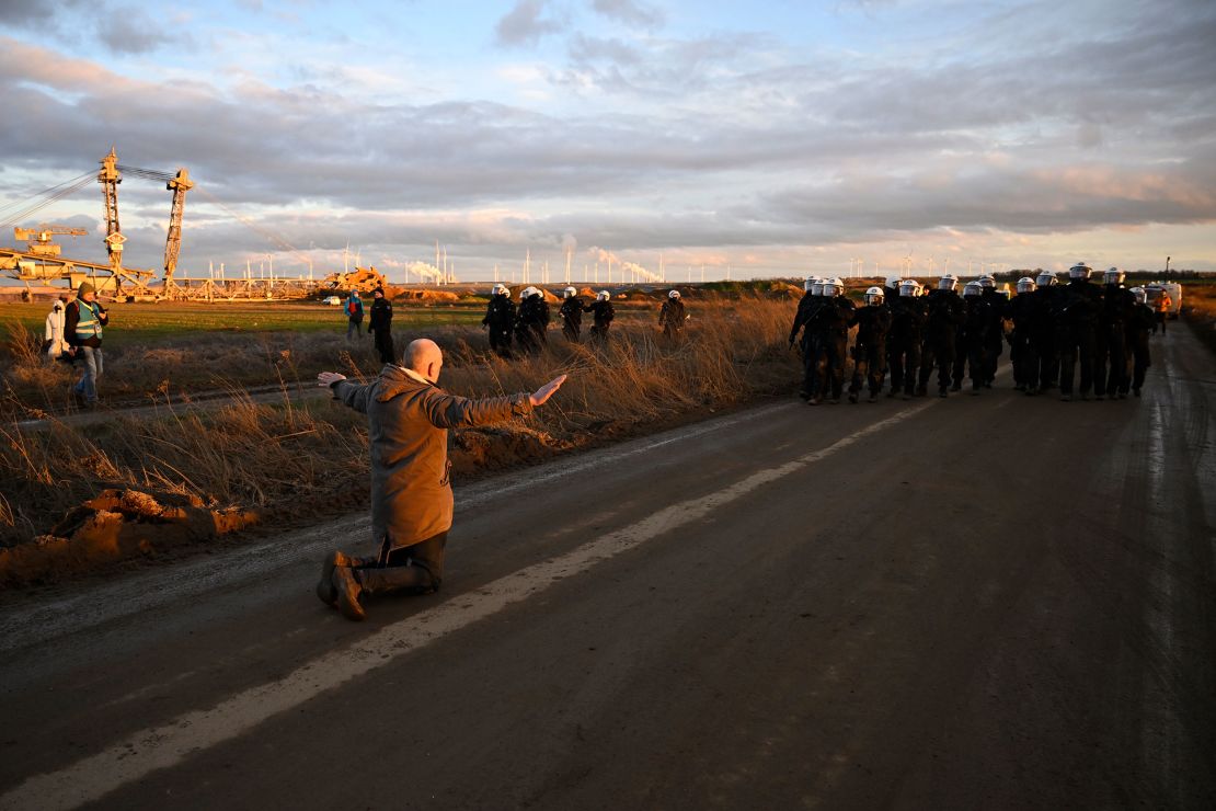 An activist kneels in front of riot police next to the Garzweiler II coal mine on January 8.