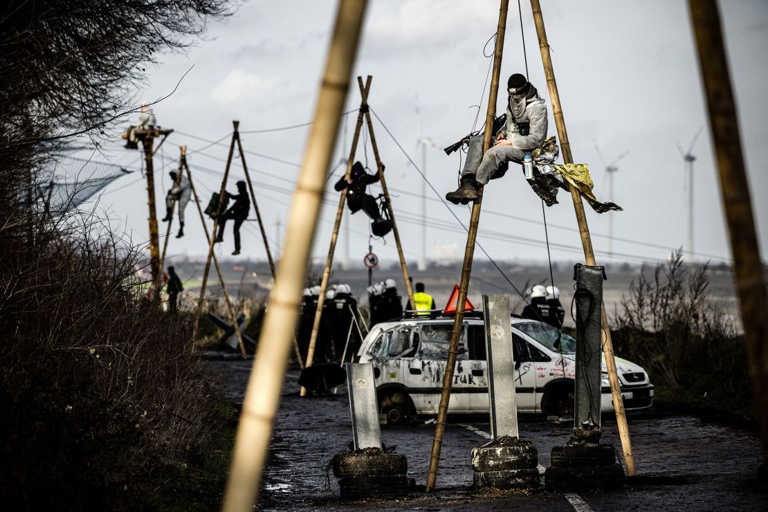 German police work to remove activists from poles in the occupied village of Lützerath.