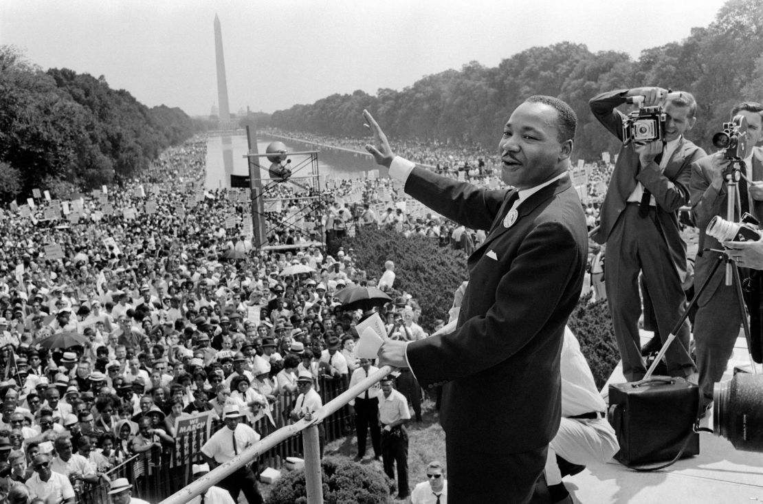 Civil rights leader Martin Luther King Jr. waves to supporters on August 28, 1963, on the Mall in Washington. His speech spoke of Black and White people sitting together "at the table of brotherhood."