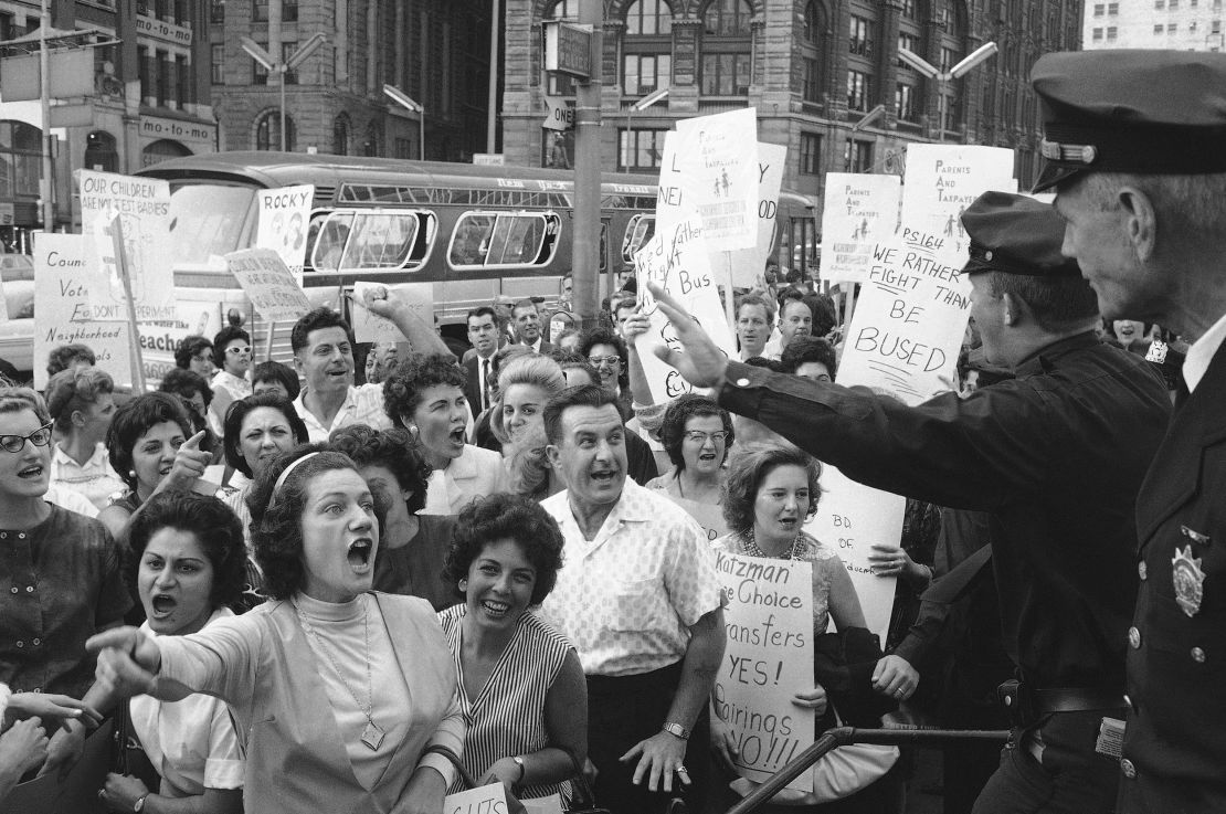 Demonstrators shout at policemen outside City Hall on Sept. 24, 1964, as they protest a  busing program aimed at increasing racial balance in New York City schools. 