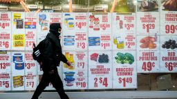 A pedestrian walks past a grocery store window showing advertisements in Queens, New York, the United States on Dec. 23, 2022. The U.S. personal consumption expenditures PCE price index in November grew 0.1 percent month on month, lower than 0.2 percent of market expectations and 0.4 percent in the previous month, according to data issued by the U.S. Department of Commerce on Friday morning. 