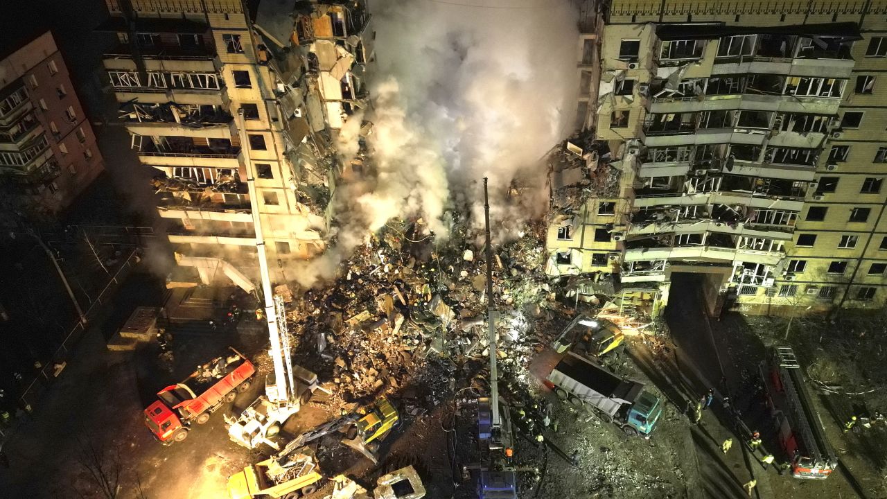 Emergency workers clear the rubble after a Russian rocket hit a multistory building leaving many people under debris in the southeastern city of Dnipro, Ukraine, Saturday, Jan. 14, 2023. (AP Photo/Evgeniy Maloletka)