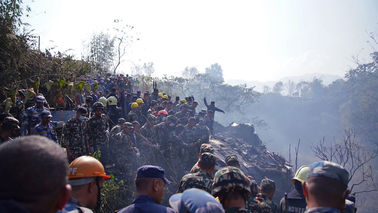 Rescuers gather at the site of a plane crash in Pokhara.