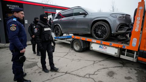 Gendarmes kijken als een luxe voertuig dat in beslag is genomen in een zaak tegen media-influencer Andrew Tate, wordt weggesleept, aan de rand van Boekarest, Roemenië, zaterdag 14 januari 2023.