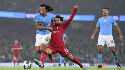 Salah is tackled by Nathan Ake of Manchester City during the League Cup match between Manchester City and Liverpool at Etihad Stadium on December 22, 2022. 