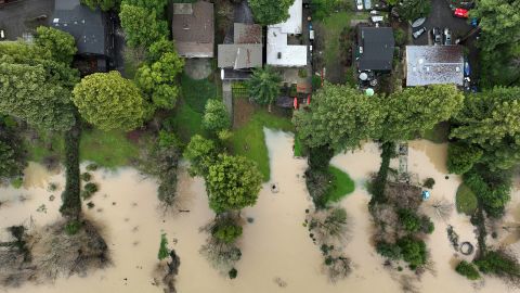 Russian River floodwaters approach homes Sunday after a series of winter storms in Guerneville, Calif.