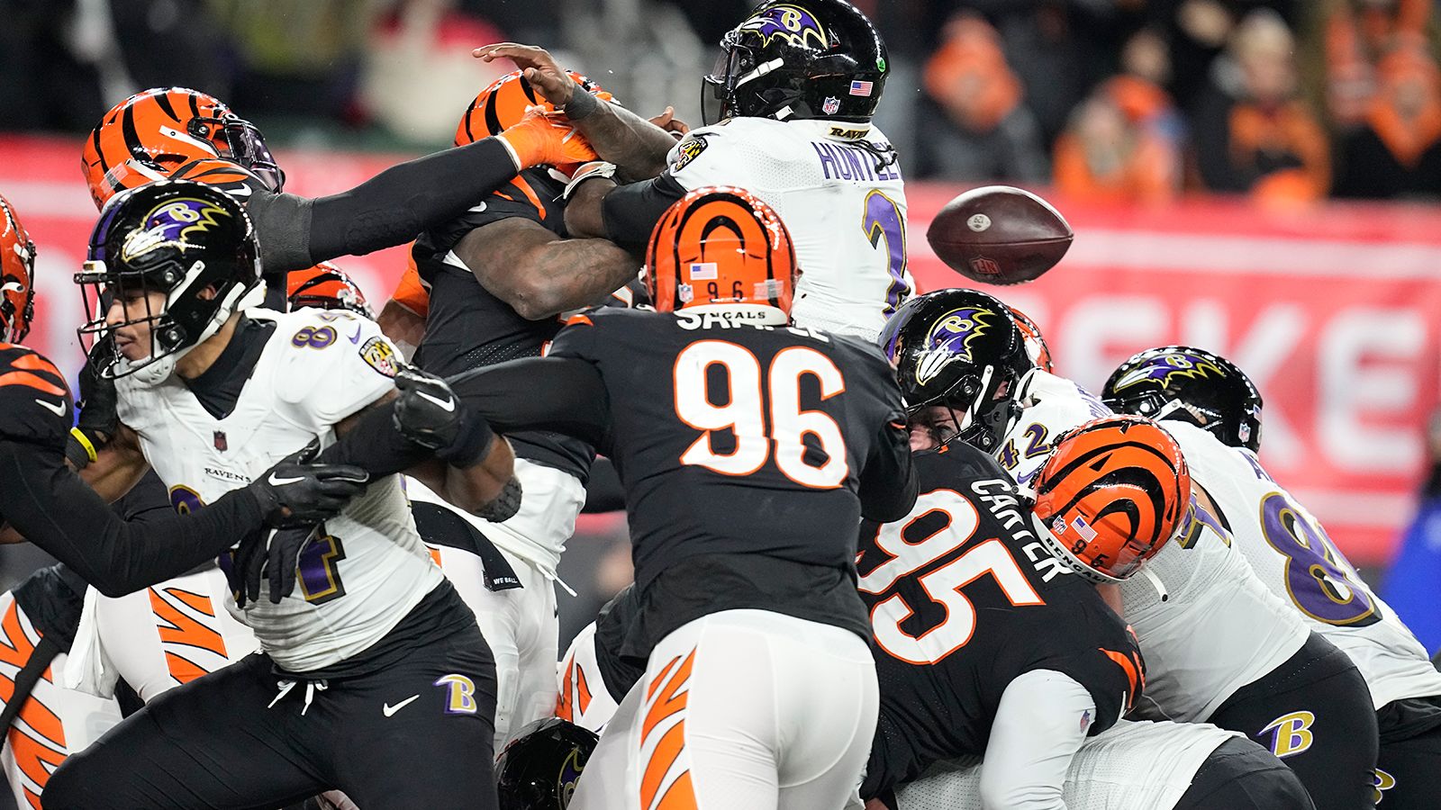 Baltimore Ravens quarterback Tyler Huntley loses the ball as it is knocked away by Cincinnati Bengals linebacker Logan Wilson. Bengals defensive end Sam Hubbard picked up the fumble and returned it for a 98-yard touchdown in a game-changing moment in Cincinnati's 24-17 victory. 