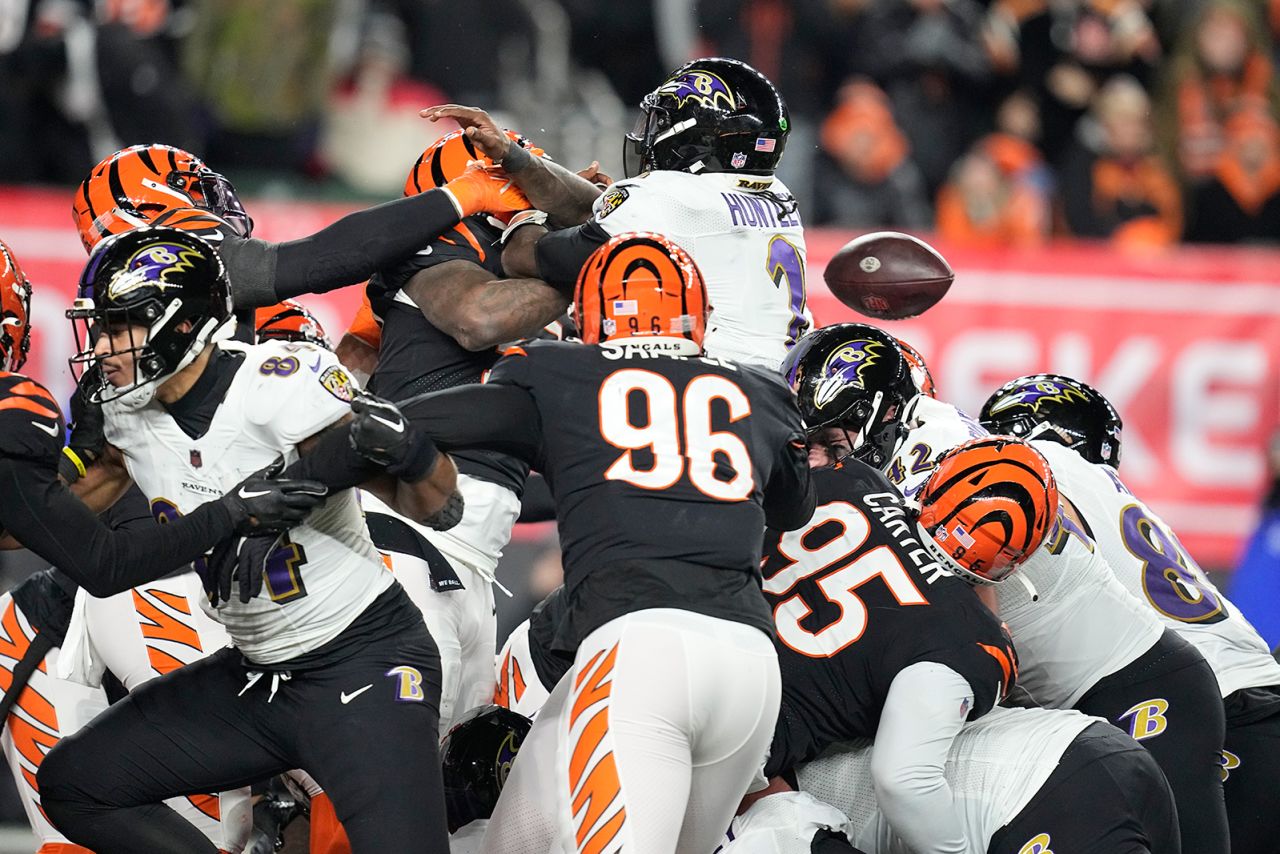 Baltimore Ravens quarterback Tyler Huntley loses the ball as it is knocked away by Cincinnati Bengals linebacker Logan Wilson. Bengals defensive end Sam Hubbard picked up the fumble and returned it for a 98-yard touchdown in a game-changing moment in Cincinnati's 24-17 victory. 