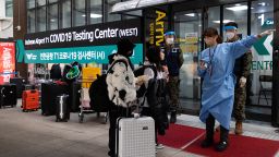 A healthcare worker assists travelers arriving outside a Covid-19 testing center at Incheon International Airport in Incheon, South Korea, on Friday, January 6, 2023. 