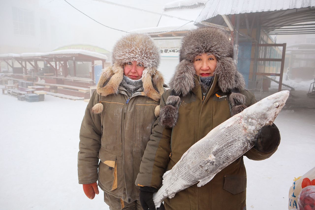 Fish vendors Marina Krivolutskaya and Marianna Ugai pose for a picture at an open-air market on a frosty day in Yakutsk, Russia, January 15, 2023. 