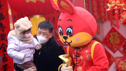 People pose for photos with a staff member in a red rabbit costume at a market on January 13 in Shijiazhuang, China. 