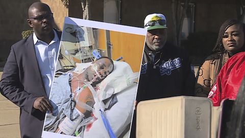 Tyre Nichols' stepfather, Rodney Wells (center), stands next to a photo of Nichols in the hospital after his arrest, during a protest in Memphis in this photo provided by WREG. 