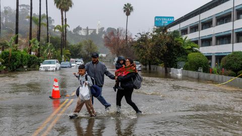 People walk on a flooded street in San Diego Monday.