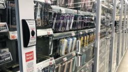 Anti-theft locked beauty products with customer service button at Walgreens pharmacy, Queens, New York.