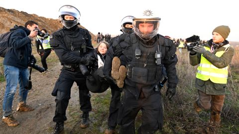 Police carry Thunberg out of a group of protesters and activists and away from the edge of the Garzweiler II opencast lignite mine.