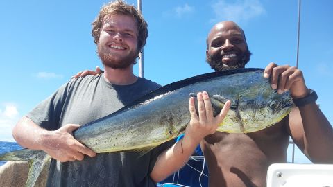 Isaac Danian and Shukree Abdul-Rashed after catching a fish on the boat Zulu Time. 