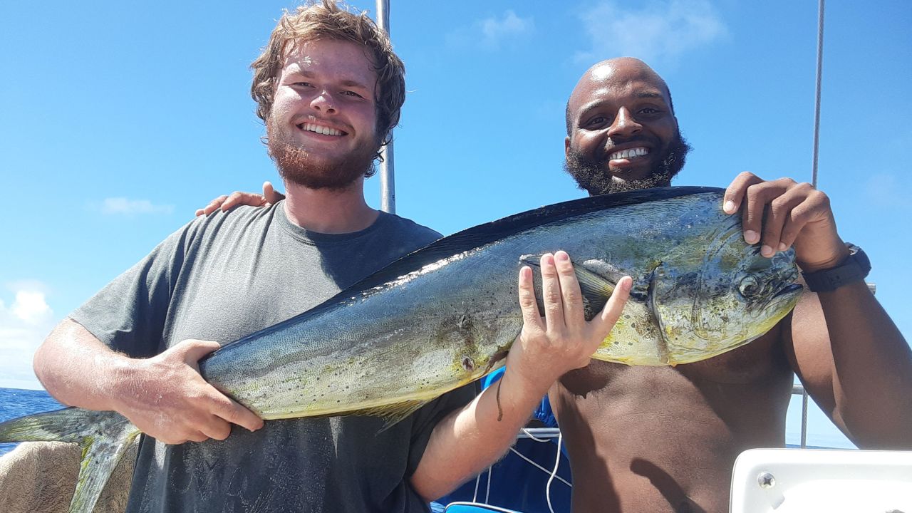 Isaac Danian and Shukree Abdul-Rashed after catching a fish on the boat "Zulu Time". 