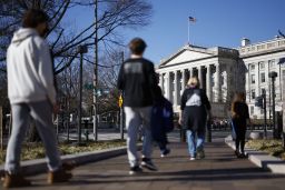 Pedestrians near the US Treasury building in Washington, DC, US, on Friday, Dec. 30, 2022. 