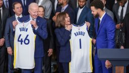 President Joe Biden holds up a jersey with "Biden" and "46" printed on the back and Vice President Kamala Harris holds up a jersey with "Harris" and "1" printed on the back as Stephen Curry looks on during an event to honor the 2022 NBA champion Golden State Warriors in the East Room of the White House on January 17, 2023 in Washington, DC. 