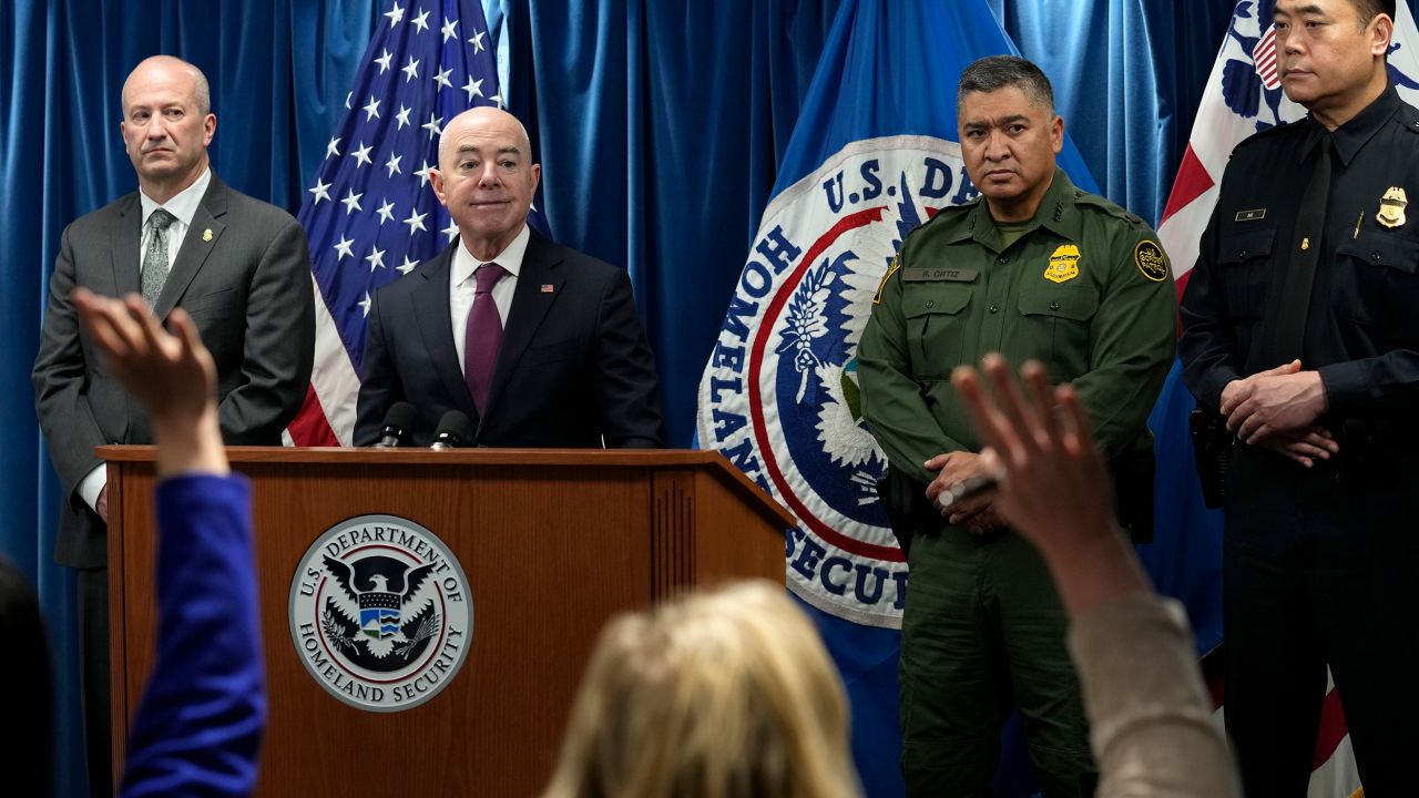 Homeland Security Secretary Alejandro Mayorkas, second from left, looks to responder to a reporter's question during a news conference.