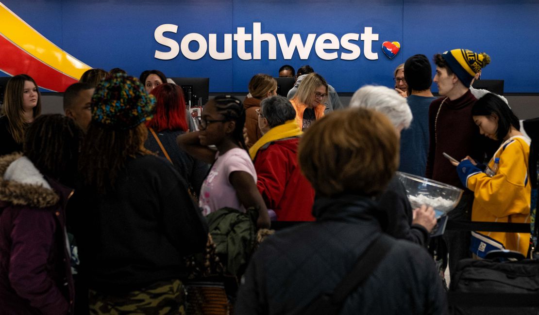 Travelers wait in line at the Southwest Airlines ticketing counter at Nashville International Airport after the airline canceled thousands of flights in Nashville, Tennessee, on December 27, 2022. - More than 10,000 flights canceled over the Christmas holiday, chaos at airports across America: Southwest Airlines found itself in the hot seat on December 27, 2022, as the airline behind the lion's share of the weather-linked travel mayhem.